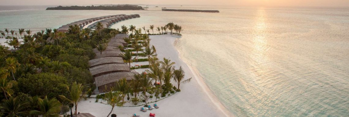 Club Med Villas de FInolhu, aux Maldives - Vue aérienne de la plage avec les villas devant la lagune au coucher du soleil