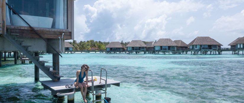 Club Med Kani, aux Maldives - Un couple est sur leur balcon extérieure et se baigne dans l'Océan.