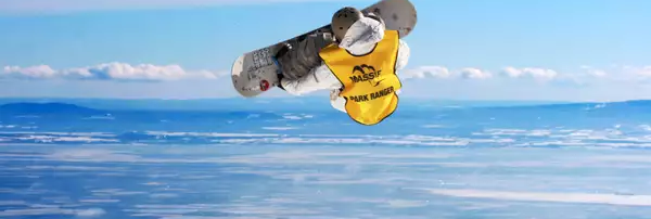 Personne qui saute avec une planche à neige avec le fleuve Saint-Laurent en arrière plan