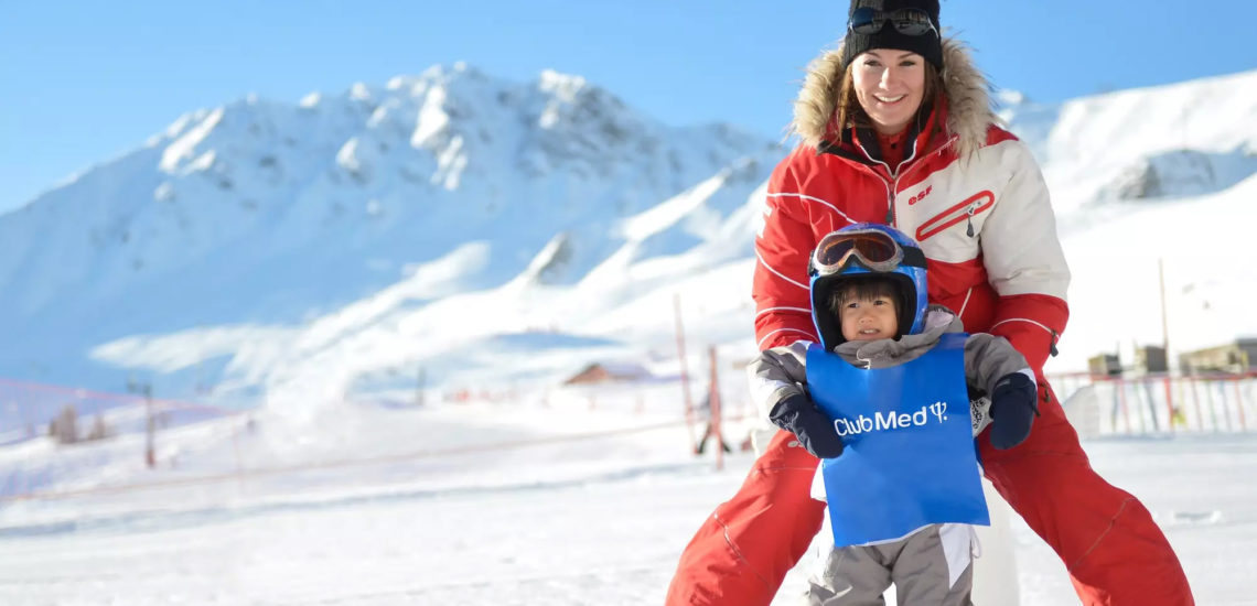 Club Med La Plagne 2100, France - Une G.O aide un jeune enfant à faire ses débuts en ski